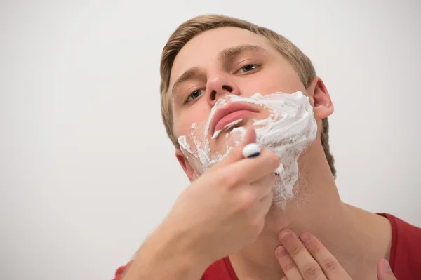 Feliz jovem adulto homem barbear seu rosto sobre fundo branco — Fotografia de Stock