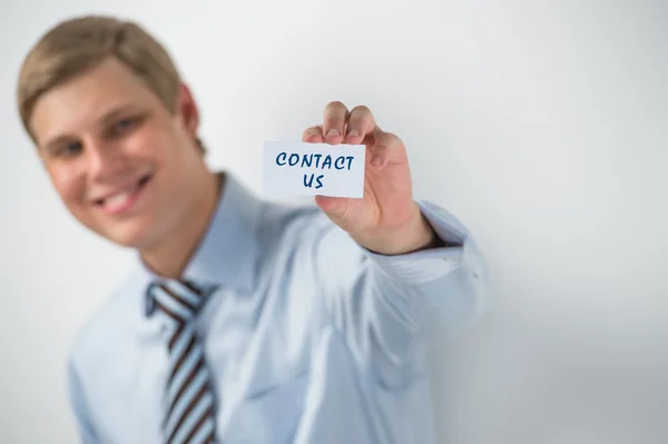 Bonito empresário mostrando "entre em contato conosco" texto em um cartão de visita — Fotografia de Stock