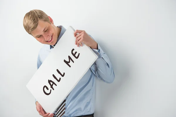 Stilig affärsman visar "ring mig" text på en skylt — Stockfoto
