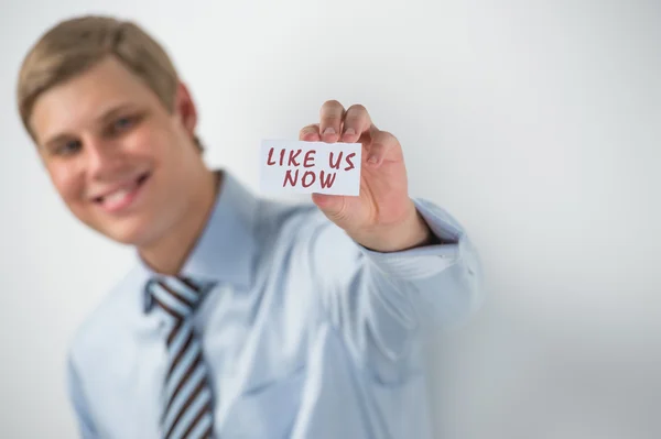 Schöner Geschäftsmann zeigt "wie wir jetzt" Text auf einer Visitenkarte — Stockfoto