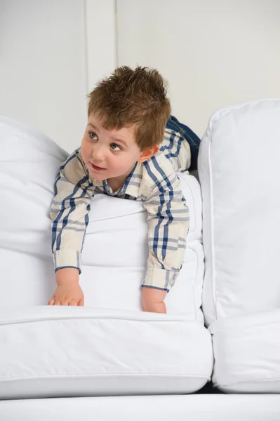 Söt liten pojke spelar hemma på soffan — Stockfoto