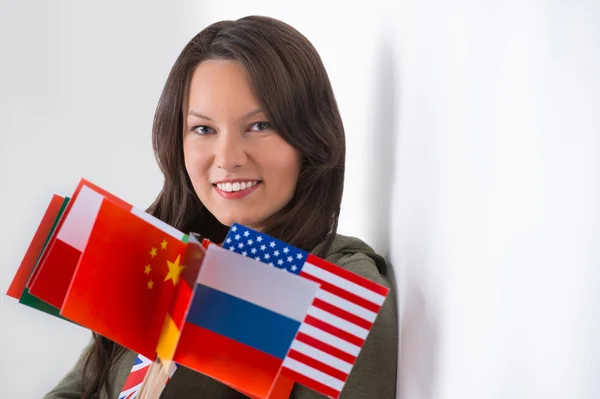 Retrato de una joven encantadora con banderas de diferentes países — Foto de Stock