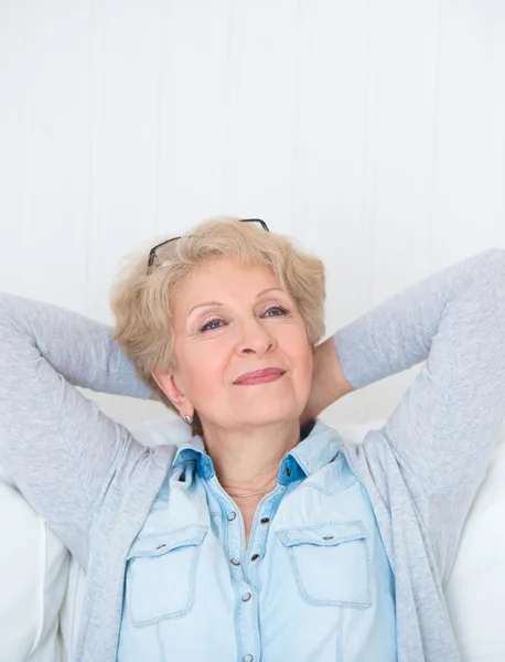 Glücklich lächelnde Seniorin entspannt sich zu Hause — Stockfoto