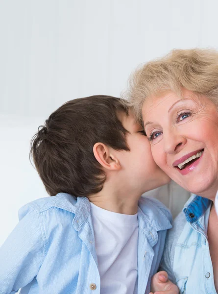 Grandmother with grandson having fun at home - whispering secret — Stock Photo, Image