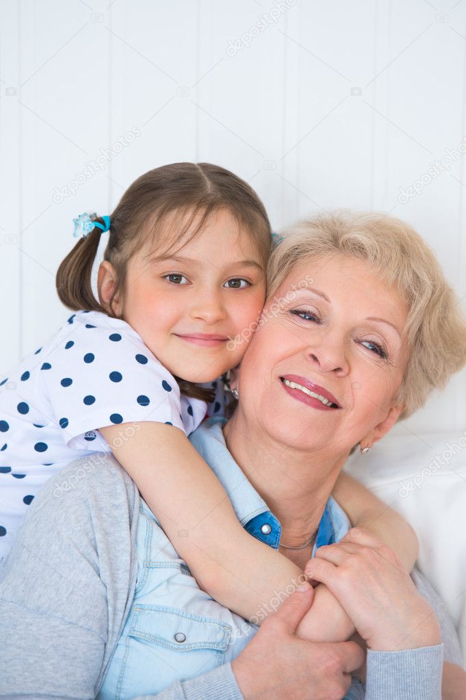 Lovely little girl with her grandmother having fun and happy mom