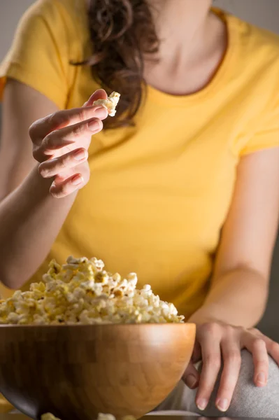 Unrecognizable woman eating popcorn at the cinema — Stock Photo, Image