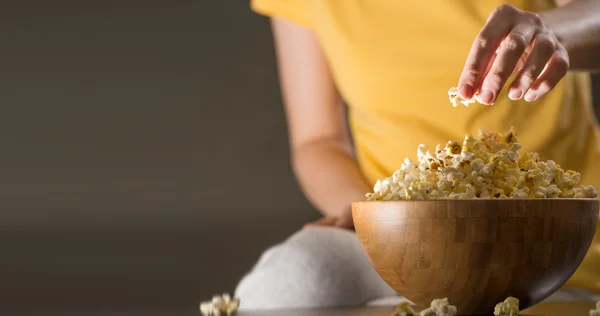 Mulher irreconhecível comendo pipocas no cinema — Fotografia de Stock