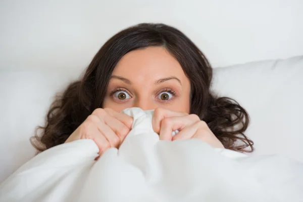 Mädchen versteckt ihr Gesicht im Bett — Stockfoto