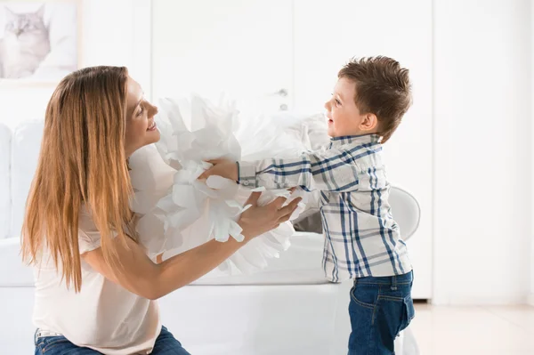 Radosnego malucha gra z domu ozdoba papier i jego matka — Zdjęcie stockowe