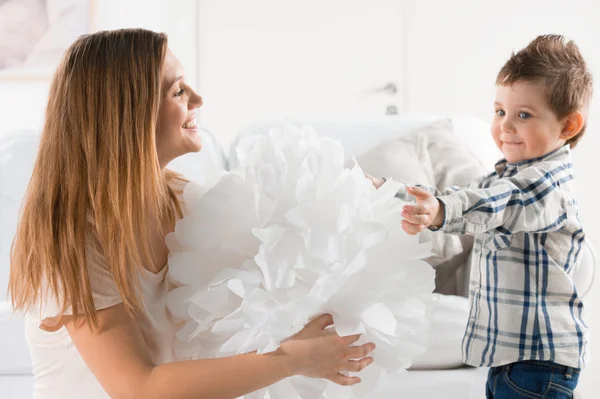 Joyeux tout-petit jouant avec la décoration de la maison en papier et sa mère — Photo