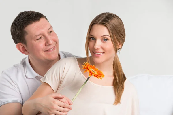 Homem olhando para sua bela namorada e dando-lhe uma flor — Fotografia de Stock