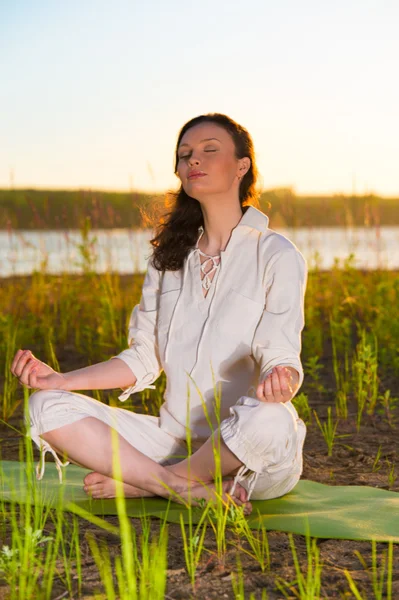 Güzel bir genç kadın yoga yaparken — Stok fotoğraf