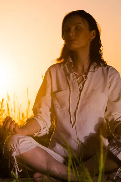 Schöne Yoga-Frau sitzt gegen Sonnenaufgang — Stockfoto