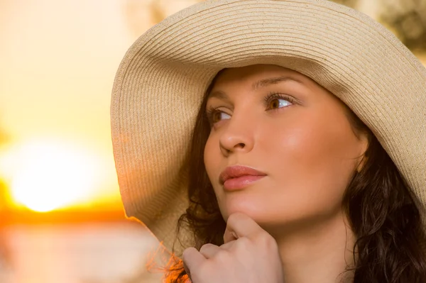 Young and beautiful woman wearing a hat in sunset light Stock Image