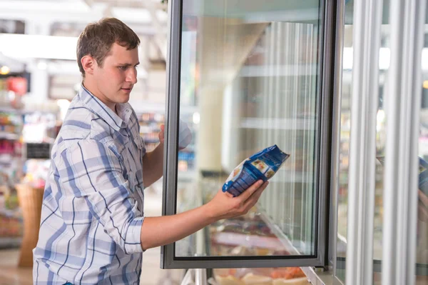 Mann im Supermarkt steht vor der Gefriertruhe — Stockfoto