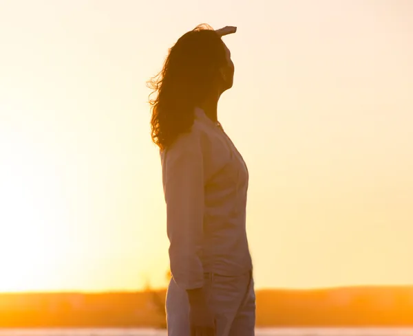 Mujer joven y hermosa en la luz del atardecer mirando lejos. Fotógrafo —  Fotos de Stock