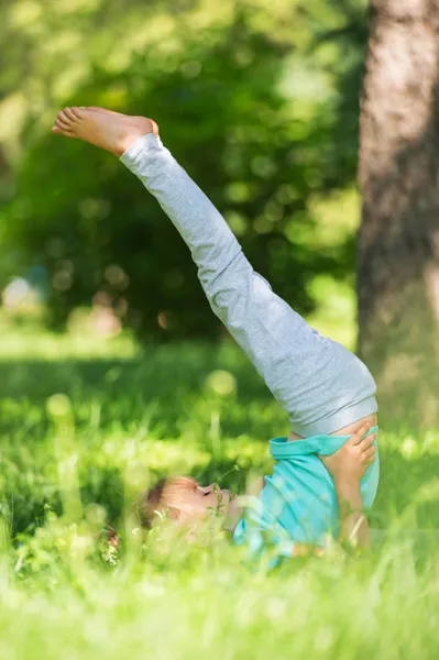 Маленькая девочка делает гимнастические упражнения — стоковое фото