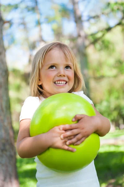 Dziewczynka gry z zielona Kula w parku — Zdjęcie stockowe