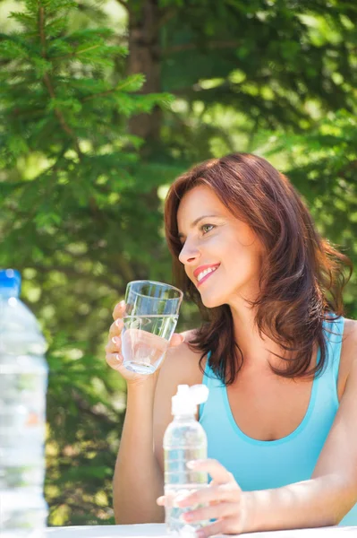 Donna che beve acqua al picnic — Foto Stock