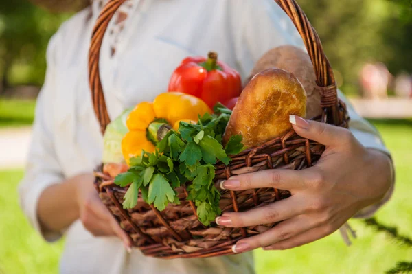 Oigenkännlig kvinna med korg full av grönsaker och bröd — Stockfoto