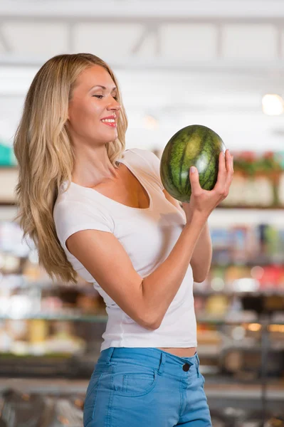 Женщина покупает арбуз в супермаркете — стоковое фото