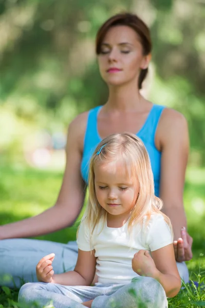 Mother and daughter doing exercise outdoors — Stock Photo, Image
