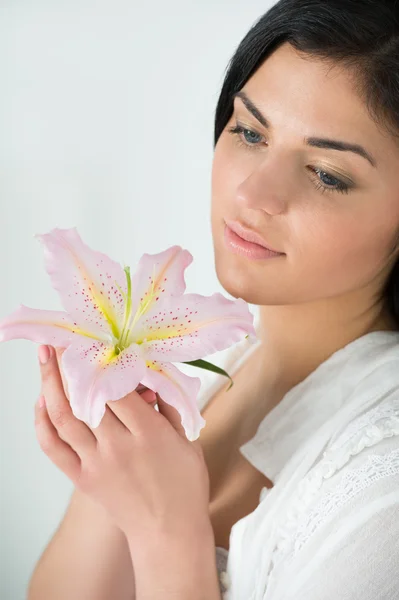 Jonge vrouw genieten van lily bloem geur — Stockfoto