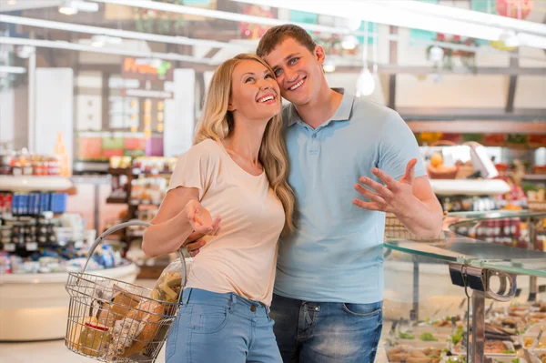 Young couple shopping at supermarket - filling cart — Stock Photo, Image