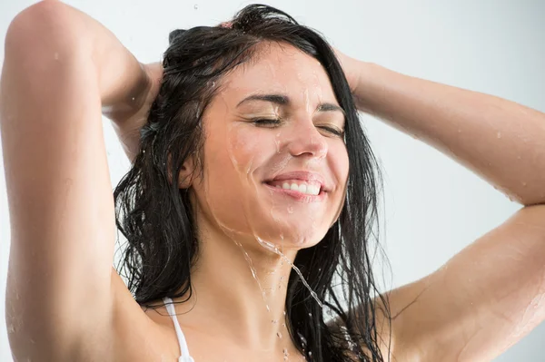 Mujer duchándose con sonrisa feliz y salpicaduras de agua —  Fotos de Stock