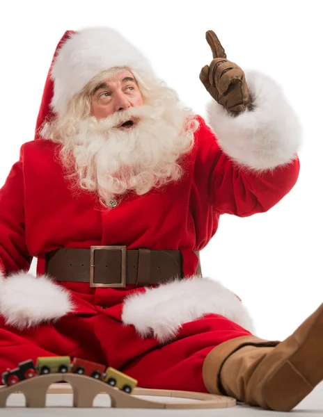 Santa Claus sitting and playing with toys — Stock Photo, Image