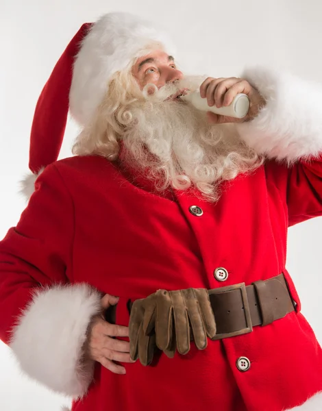 Porträtt av santa claus dricka mjölk från glasflaska — Stockfoto