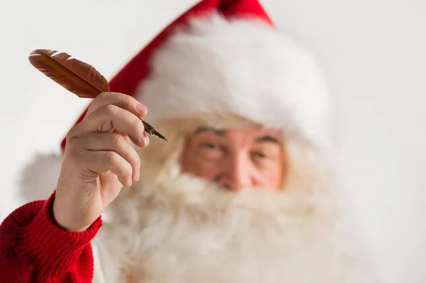 Santa Claus holding feather pen in his arm and writing — Stock Photo, Image