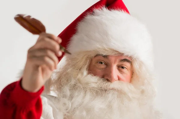 Santa Claus holding feather pen in his arm and writing — Stock Photo, Image