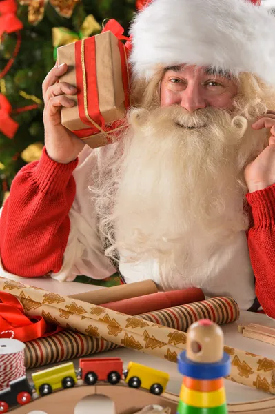 Santa Claus in his workshop making new toys — Stock Photo, Image
