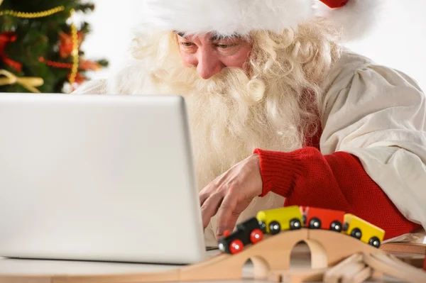 Papai Noel com barba real usando laptop — Fotografia de Stock