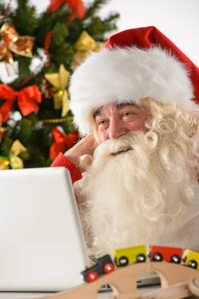 Santa claus met echte baard met behulp van laptop — Stockfoto