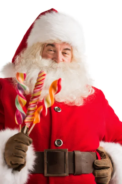 Retrato de Santa Claus feliz sosteniendo caramelos mirando a la cámara —  Fotos de Stock