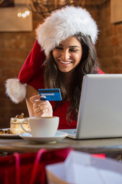 genç kadın Noel şapka takan bir kafede onun fatura ödeme