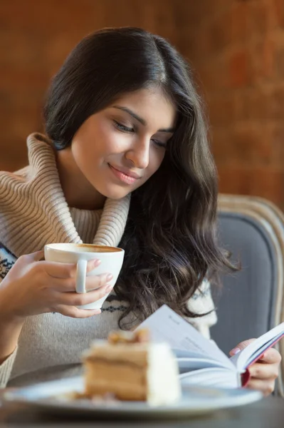 Vrouw leest een boek bij café — Stockfoto