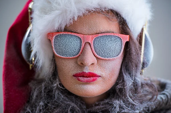 Mulher usando chapéu de Papai Noel e óculos de sol ouvindo música — Fotografia de Stock