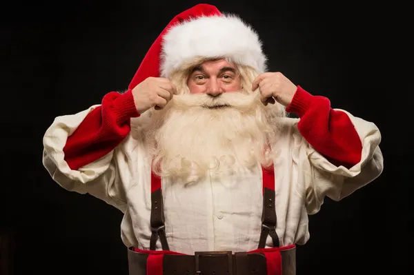 Foto van gelukkig santa claus aanraken snor — Stockfoto