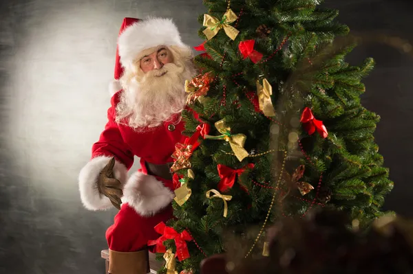 Santa claus staande in de buurt van de kerstboom — Stockfoto