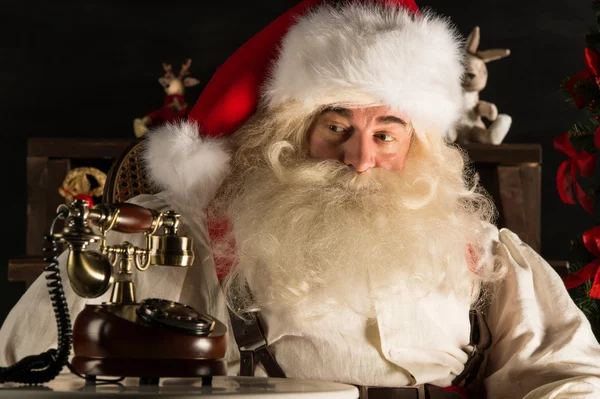 Papá Noel sentado en casa cerca del árbol de Navidad y esperando una ca —  Fotos de Stock