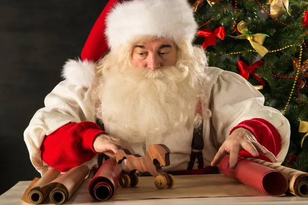 Santa Claus trabajando - preparando y envolviendo regalos de Navidad — Foto de Stock