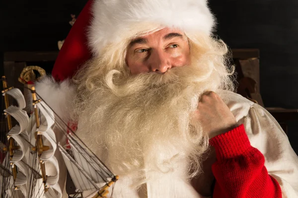 Papá Noel en casa jugando con juguetes nuevos cerca del árbol de Navidad —  Fotos de Stock