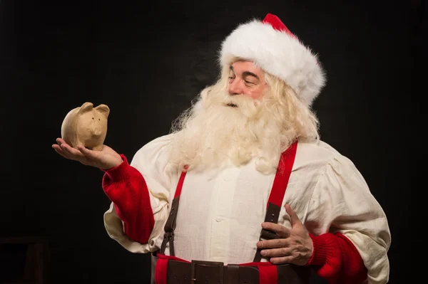 Papai Noel segurando caixa de dinheiro do banco porquinho — Fotografia de Stock