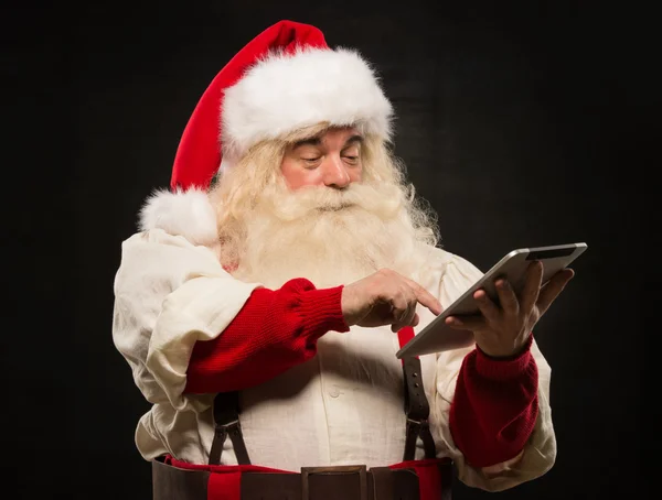Санта Клаус с помощью планшетного компьютера — стоковое фото