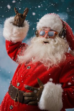 Santa Claus is listening to music in headphones outdoors at North pole