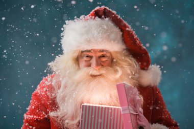 Happy Santa Claus opening his Christmas gift at North Pole clipart