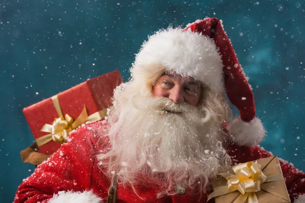 Claus al aire libre en nevadas llevando regalos —  Fotos de Stock